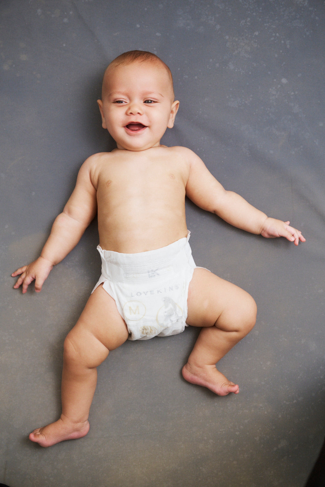 Newborn baby lying down in Lovekins TriplePro Bio nappy
